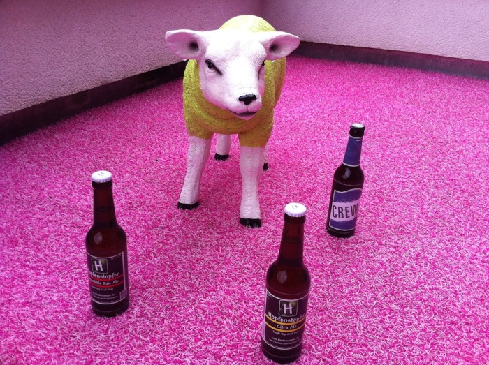 Schaf mit 3 Flaschen Bier auf einem Teppich